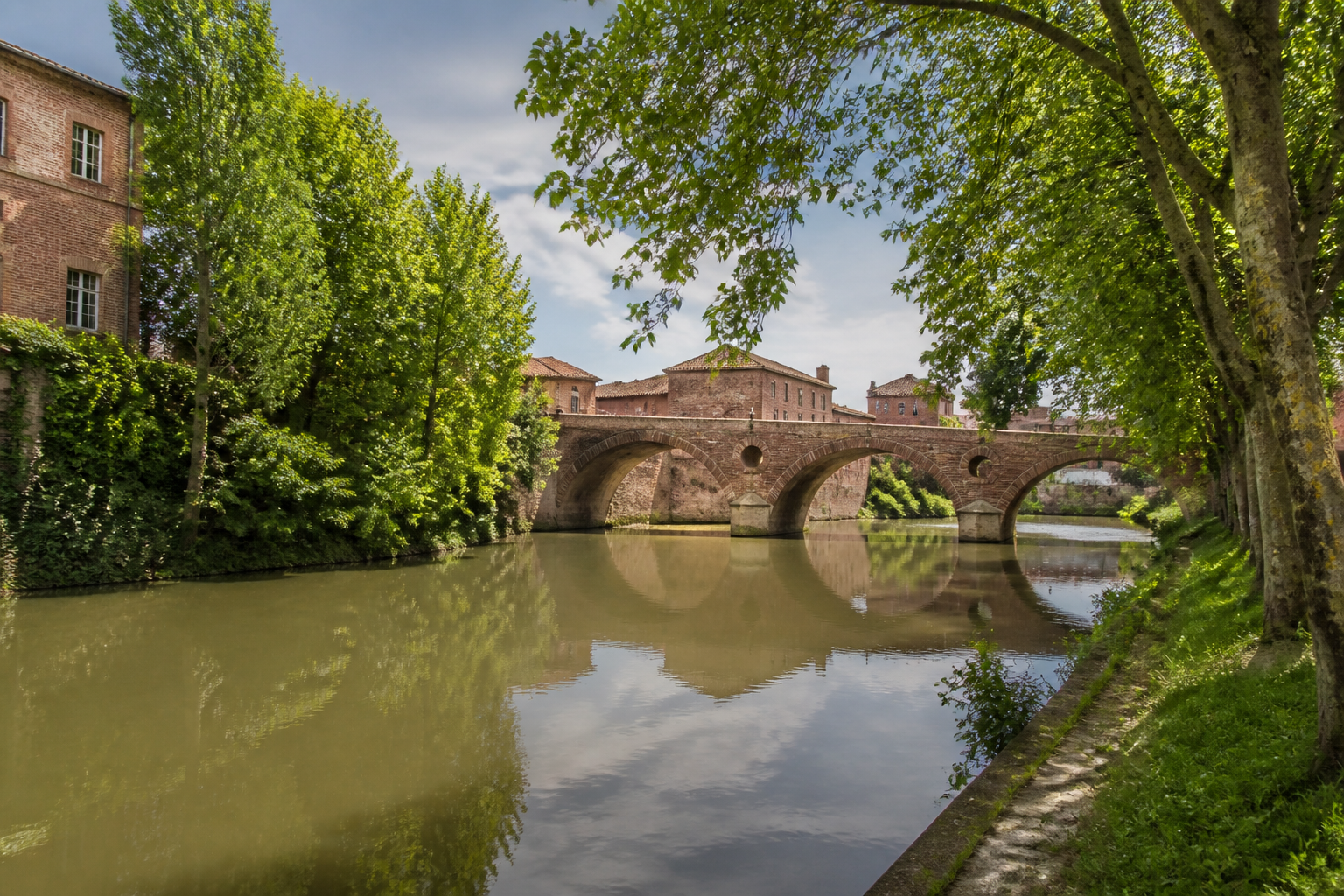 Le pont ancien sur le Touch et son environnement verdoyant à Plaisance-du-Touch.